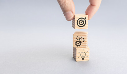Business strategy and action plan concept. Hand putting wood block with target icon on top of...