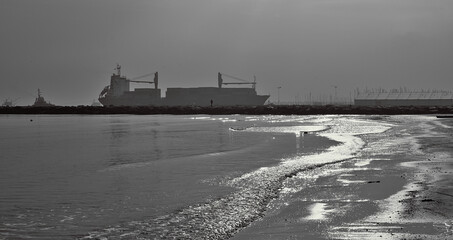 Fototapeta premium A cargo entering in the harbor under a shining sun