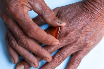 Asian elderly holding pill drug in hand