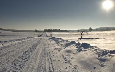 Fotobehang Winter road. Winter landscape of road. Snowy winter on the countryside, black and white picture. Highway leading through snowy fields. Drifts on the road. © Solar 760L