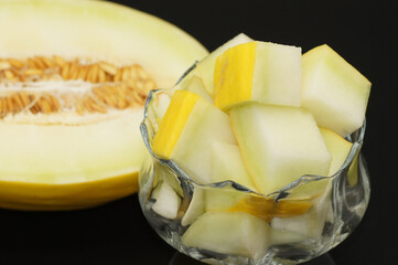 Gelbe Honigmelone freigestellt auf schwarzem Hintergrund