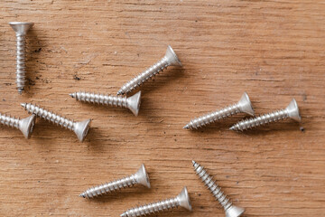 Tapping screws made of steel on table background, metal screw, iron screw, chrome screw, screws as a background, wood screw, concept industry. copy space for text.