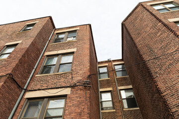 Extreme up angle view of old brick apartment buildings with square and chamfered corners, horizontal aspect