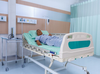 Asian old man is an elderly patient lying on a bed sleeping in a modern hospital ward in a hospital.