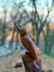 Bird wooden statue, carved wood statue isolated in forest. Selective focus image in forest
