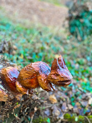 Squirrel wooden statue, carved wood statue isolated in forest. Selective focus image in forest