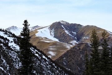 Snow-covered mountain, morning fog, mountain rocky ridges with pointed peaks, winter, sunny,...