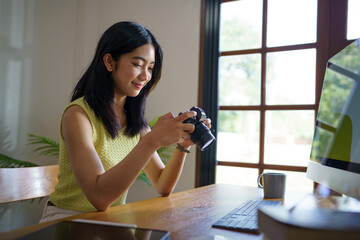 Happy young Asian Woman photographer holding camera Creative female freelancer working freelance creative artist