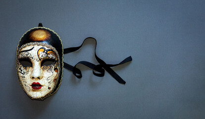 Carnival Venetian mask with braid on grey-blue background. Concept - Venetian carnival masquerade,...