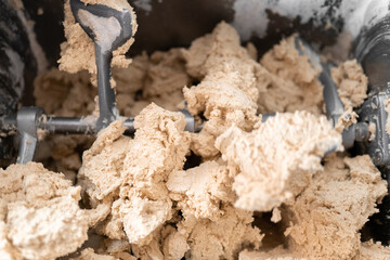 A kneading machine is mixing the corn dough to prepare tortillas in Mexico. Close up