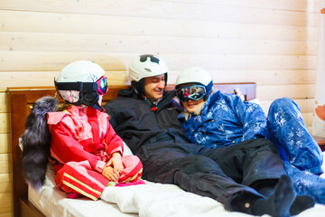 family in bed after skiing at winter resort