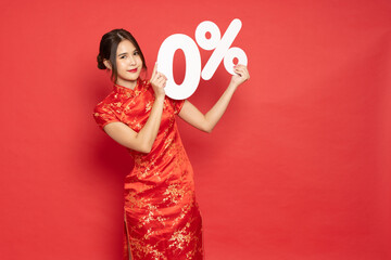 Young Asian woman wearing red traditional cheongsam qipao dress showing 0% number or zero percent isolated on red background