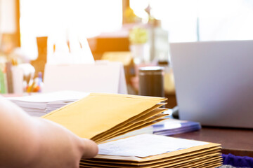 Soft focus of office clerk or secretary is preparing documents and brown envelopes for those interested in bidding for the construction of a large building in an office.