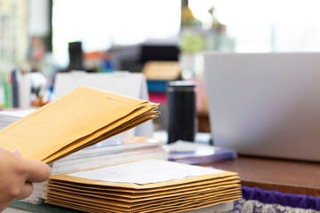 Soft focus of office clerk or secretary is preparing documents and brown envelopes for those...