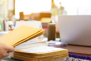 Soft focus of office clerk or secretary is preparing documents and brown envelopes for those...