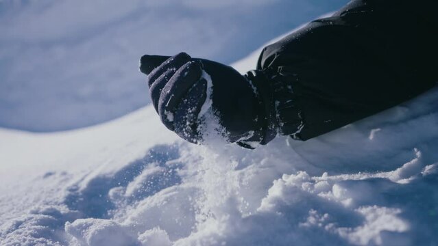 hand squeezing snow, close up