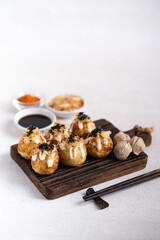 Takoyaki is Japanese Street Food containing with octopus, sausage or cheese. garnish with seaweed and katsuobushi