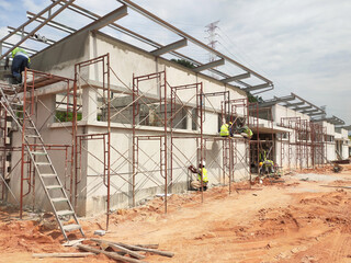 Fototapeta premium MELAKA, MALAYSIA -JUNE 19, 2022: A view of a construction site in full swing. Machines and workers are busy doing work. The safety level is ensured to reach the required standards.