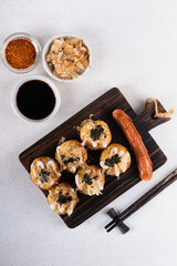 Takoyaki is Japanese Street Food containing with octopus, sausage or cheese. garnish with seaweed and katsuobushi