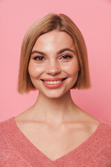 Fototapeta premium Smiling woman posing isolated over pink studio background