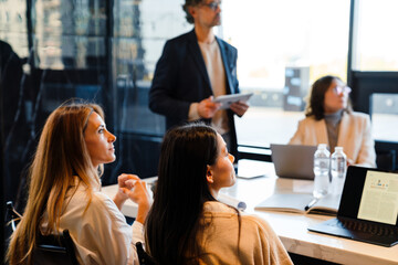 Different age colleagues examining presentation during offline meeting
