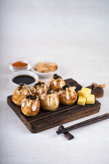 Takoyaki is Japanese Street Food containing with octopus, sausage or cheese. garnish with seaweed and katsuobushi