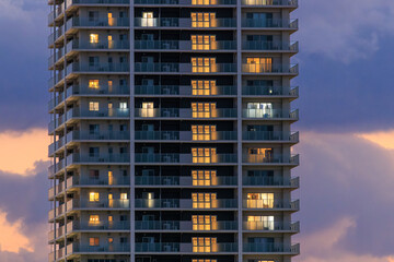 Fototapeta na wymiar Lights from luxury apartment tower against beautiful sunset sky