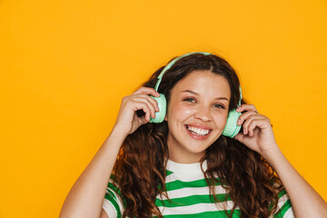 Young woman wearing headphones smiling and listening music