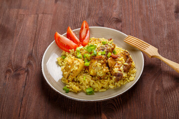 Thai chicken rice on a wooden table next to a wooden fork.