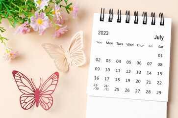 A July 2023 desk calendar for the organizer to plan, reminder and butterfly paer with flower on yellow background.