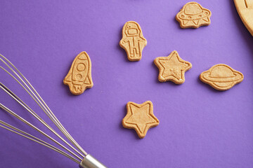 Cookies, stars and astronaut for world cosmonautics day. cookies on purple background. Space and astronomy concept