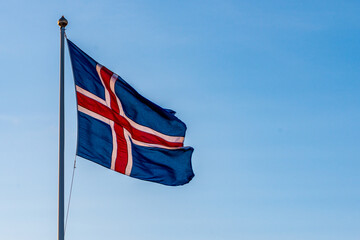 Icelandic flag moving in the wind isolated in front of blue sky