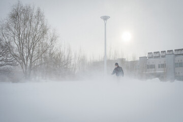 Man walking during a snow storm in a street at Sapporo city of Japan.