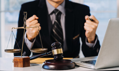 Business and lawyers discussing contract papers with brass scale on desk in office. Law, legal services, advice, justice and law concept.