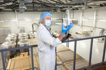 Technologist focused on examining the contents of a glass vessel