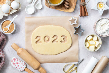 Homemade cookie dough in the form of numbers 2023. The concept of baking for New Year and Christmas.