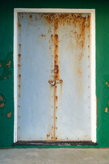 Green beach hut with silver metal doors at Bexhill-on-Sea, East Sussex, England