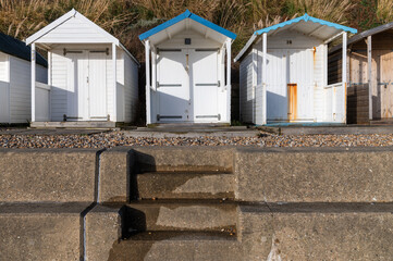 White wooden beach huts at Bexhill-on-Sea on a sunny day