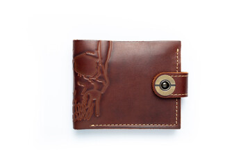 Brown leather wallet on a button on a white background, scull print. Top view