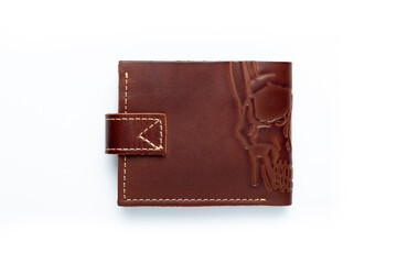 Brown leather wallet on a button on a white background, scull print. Top view