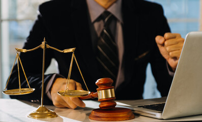 Business and lawyers discussing contract papers with brass scale on desk in office. Law, legal services, advice, justice and law concept.