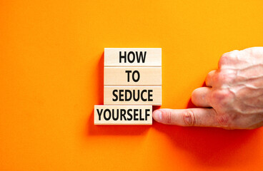 How to seduce yourself symbol. Concept word How to seduce yourself on wooden blocks. Businessman hand. Beautiful orange table orange background. Business and how to seduce yourself concept. Copy space