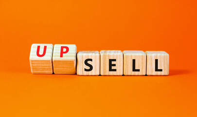 Sell or upsell symbol. Concept word Sell Upsell on wooden cubes. Beautiful orange table orange...