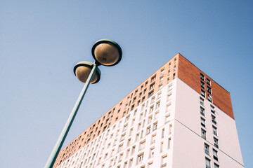 Immeuble avec ciel bleu et lampadaire dans un quartier populaire