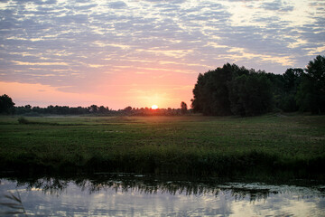 Fototapeta na wymiar magical sunrise over the forest lake