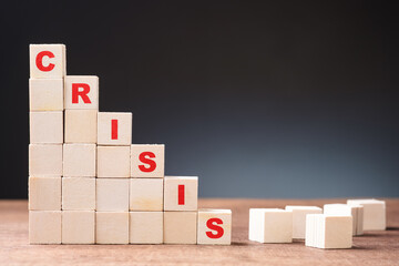 Stepping down of stack wood cubes with Crisis word, economic recession, business in crisis, crisis...