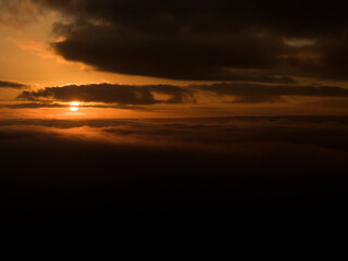 Fototapeta na wymiar An Orange Sun Rise bursts Through Clouds