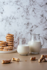 milk in a glass and bagels on a light background