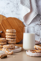 milk in a glass and bagels in glaze on the background of a marbl