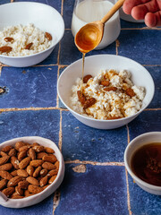 cottage cheese in a white bowl with nuts and honey